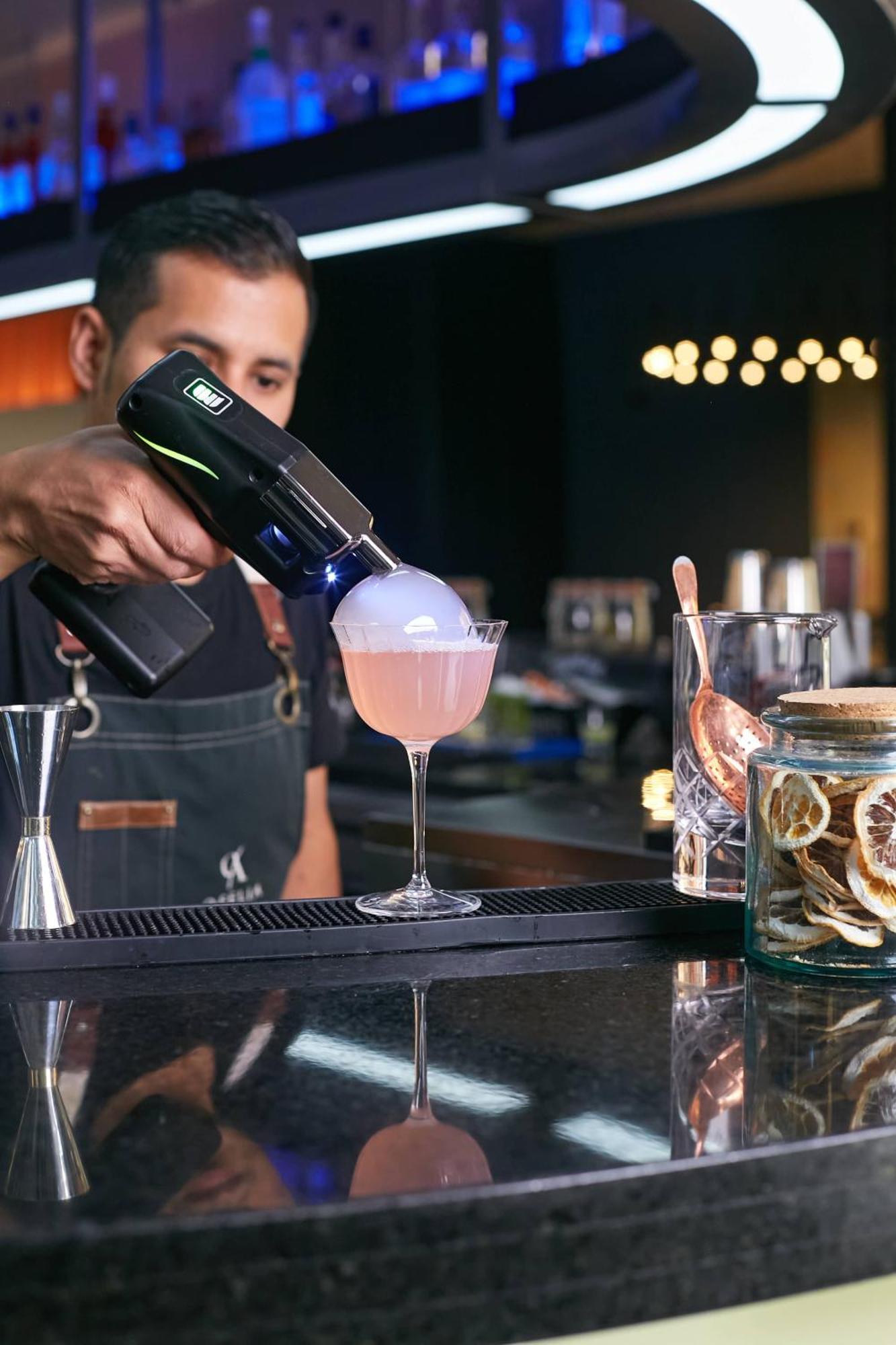 Pullman Santiago Vitacura Extérieur photo A bartender using a blowtorch to cook a cocktail